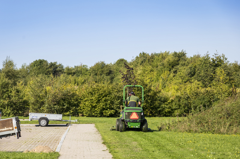 Græsplæne slås af græsslåningstraktor