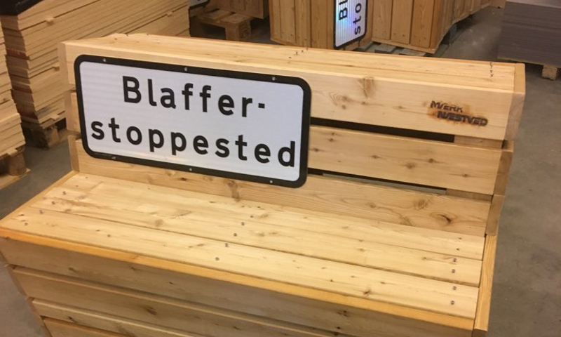 Træbænk med skilt, hvor på der står Blafferstoppested