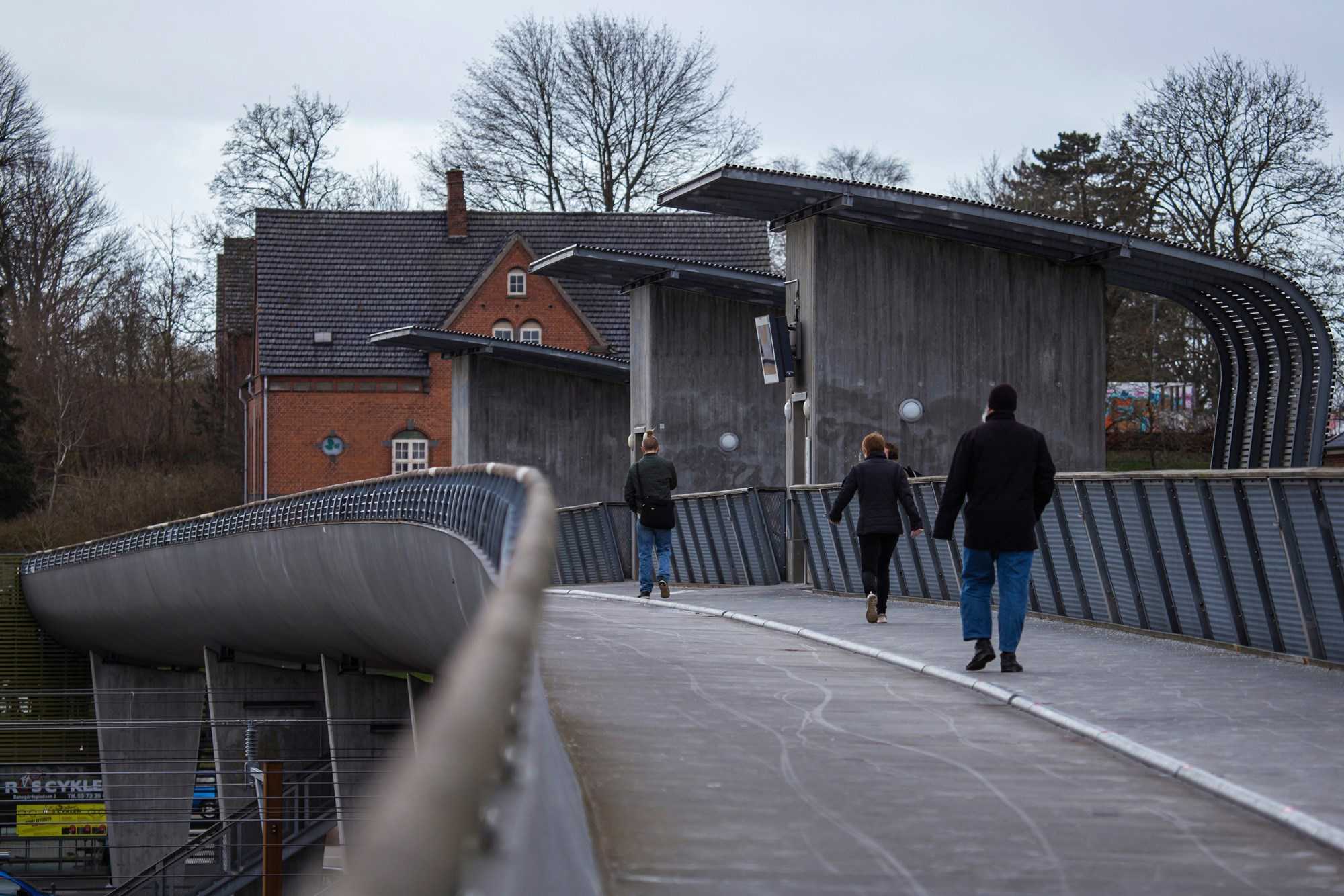 Mennesker går i raske skidt over Fodgængerbroen ved Næstved Station