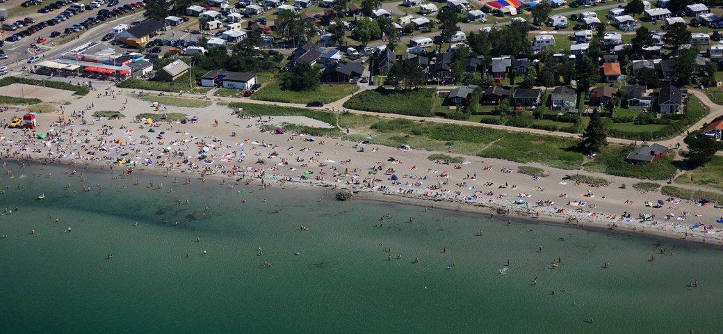 Luftfoto af Enø strand om sommeren, med mennesker der bader