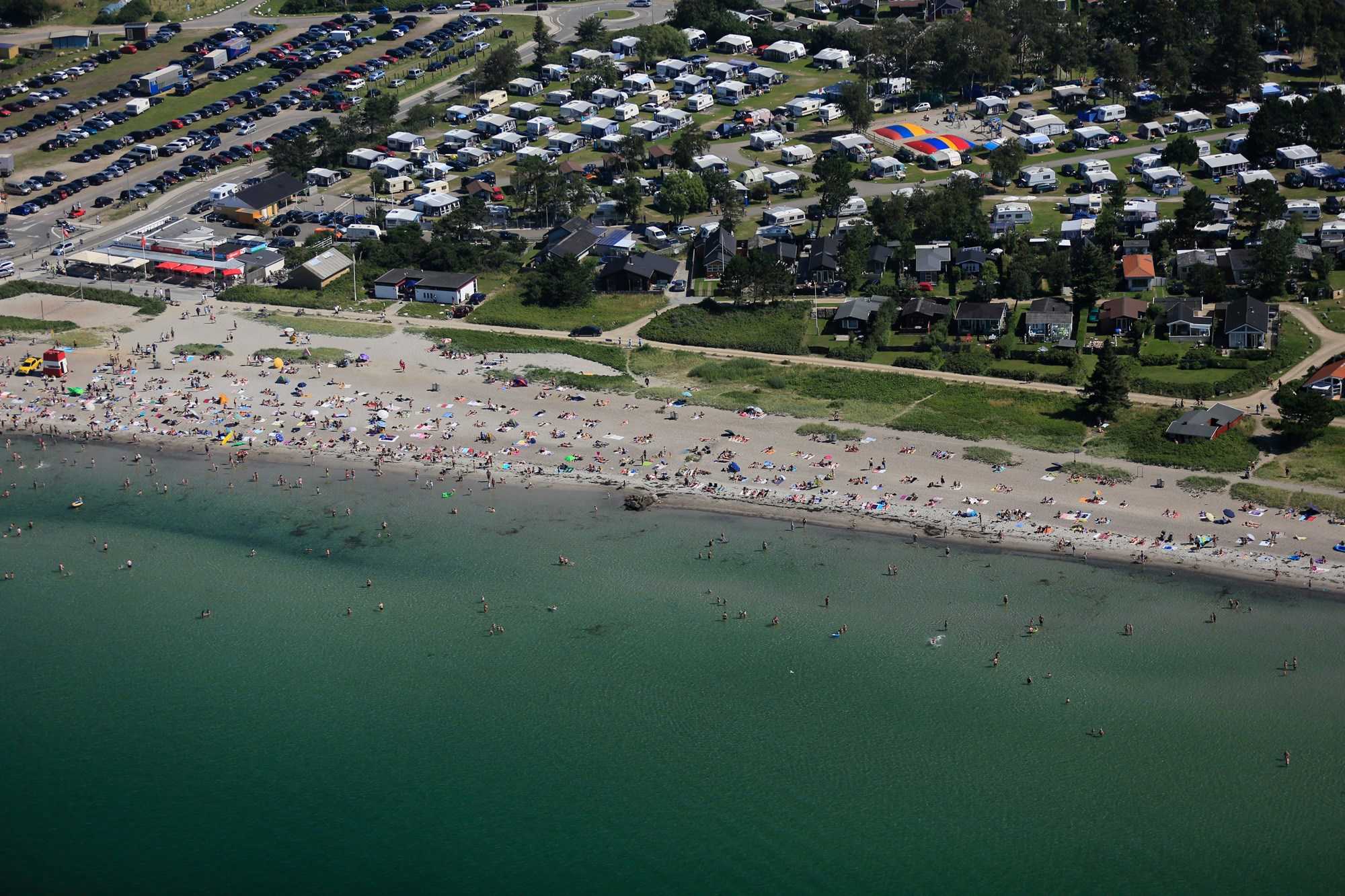 Luftfoto af Enø strand om sommeren, med mennesker der bader