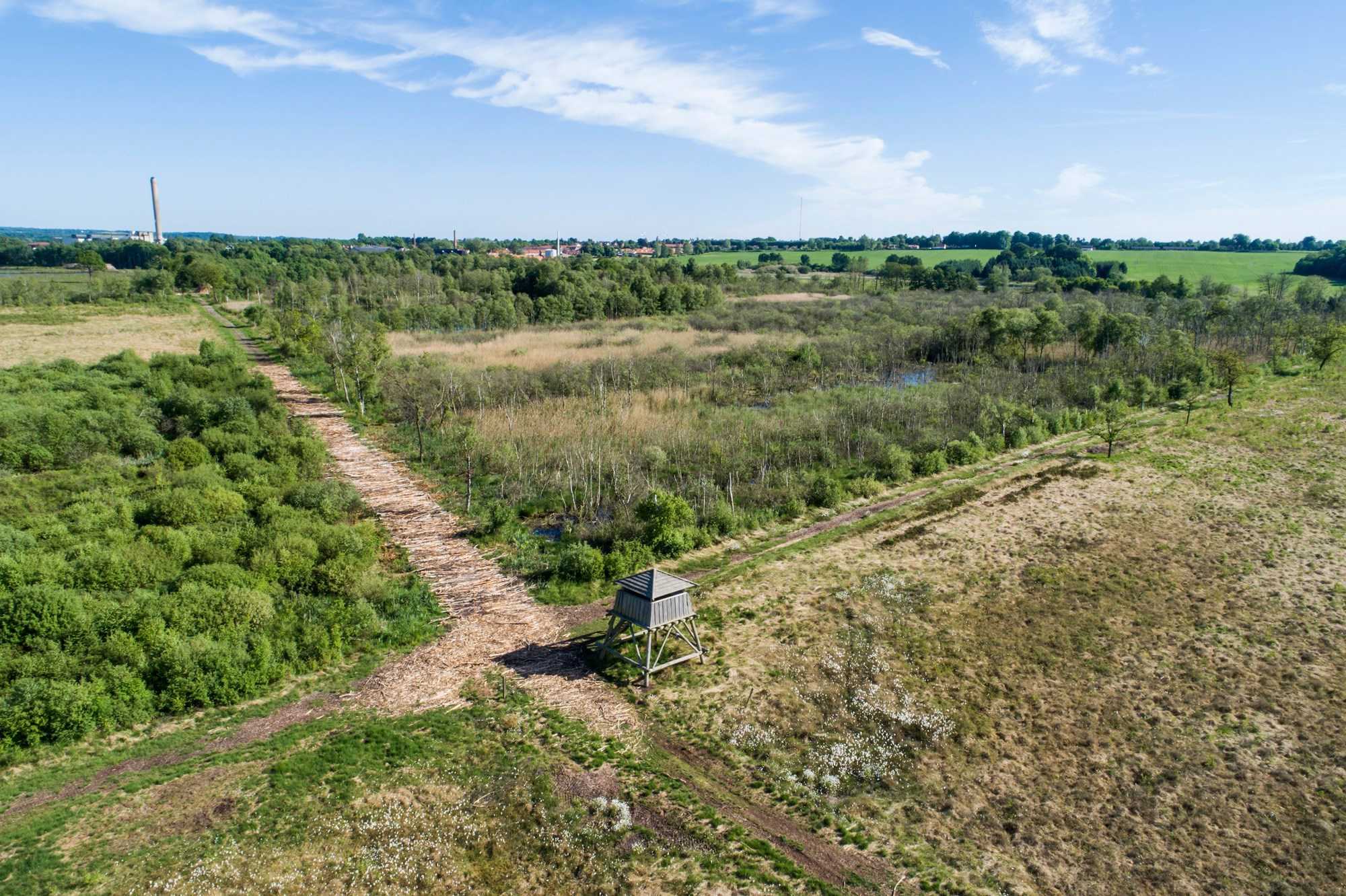 Dronefoto over mark med jagttårn 